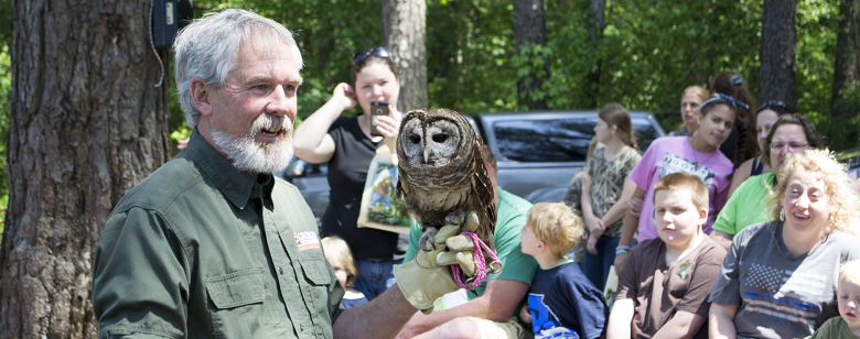 Image of a man holding a barred owl
