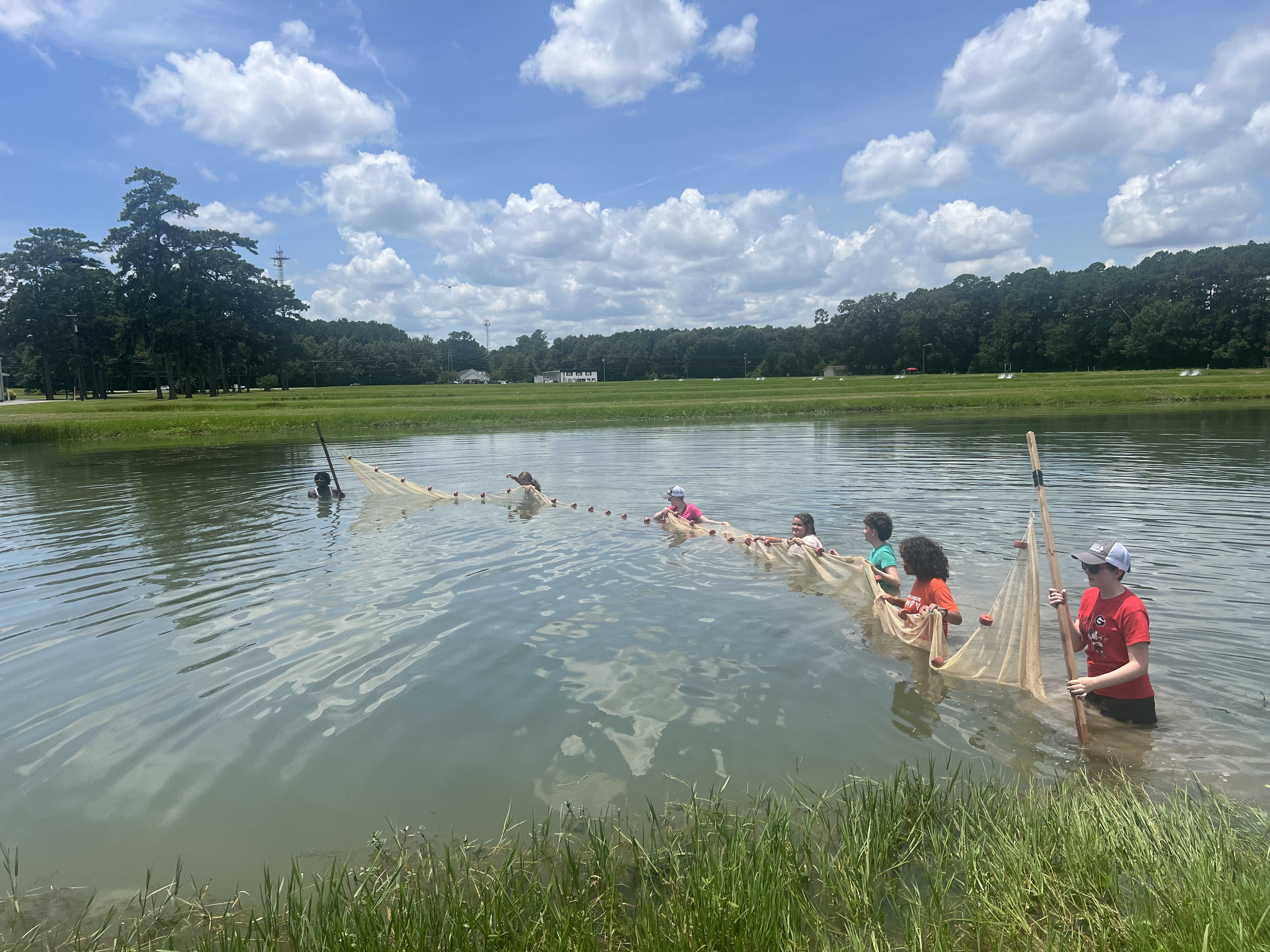 a group of students seine netting at a hatchery