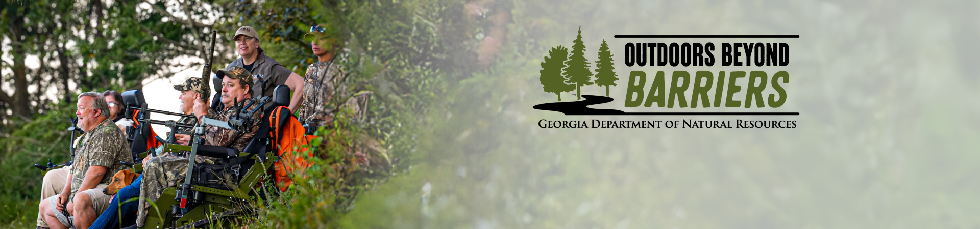 A group of people in motorized wheelchairs sat at a forest overlook and dressed in camouflage.